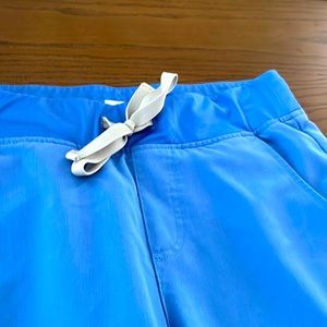 FIGS scrub bottom jogger style. NWOT. Never worn. Zippered pockets. Light blue.